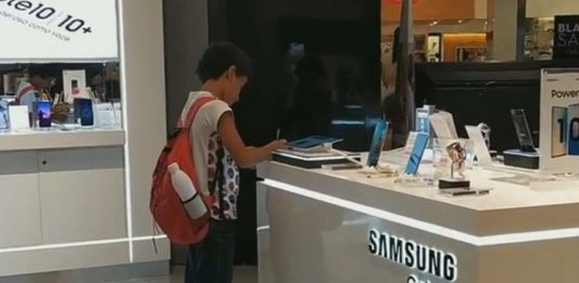 A Boy with No Computer Uses Tablet at Store to do Homework